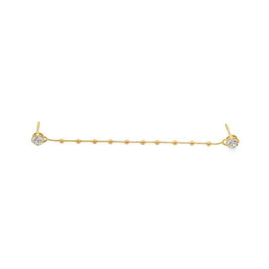 A gold double-piercing chain earring features sparkling cubic zirconia studs connected by a delicate beaded strand.