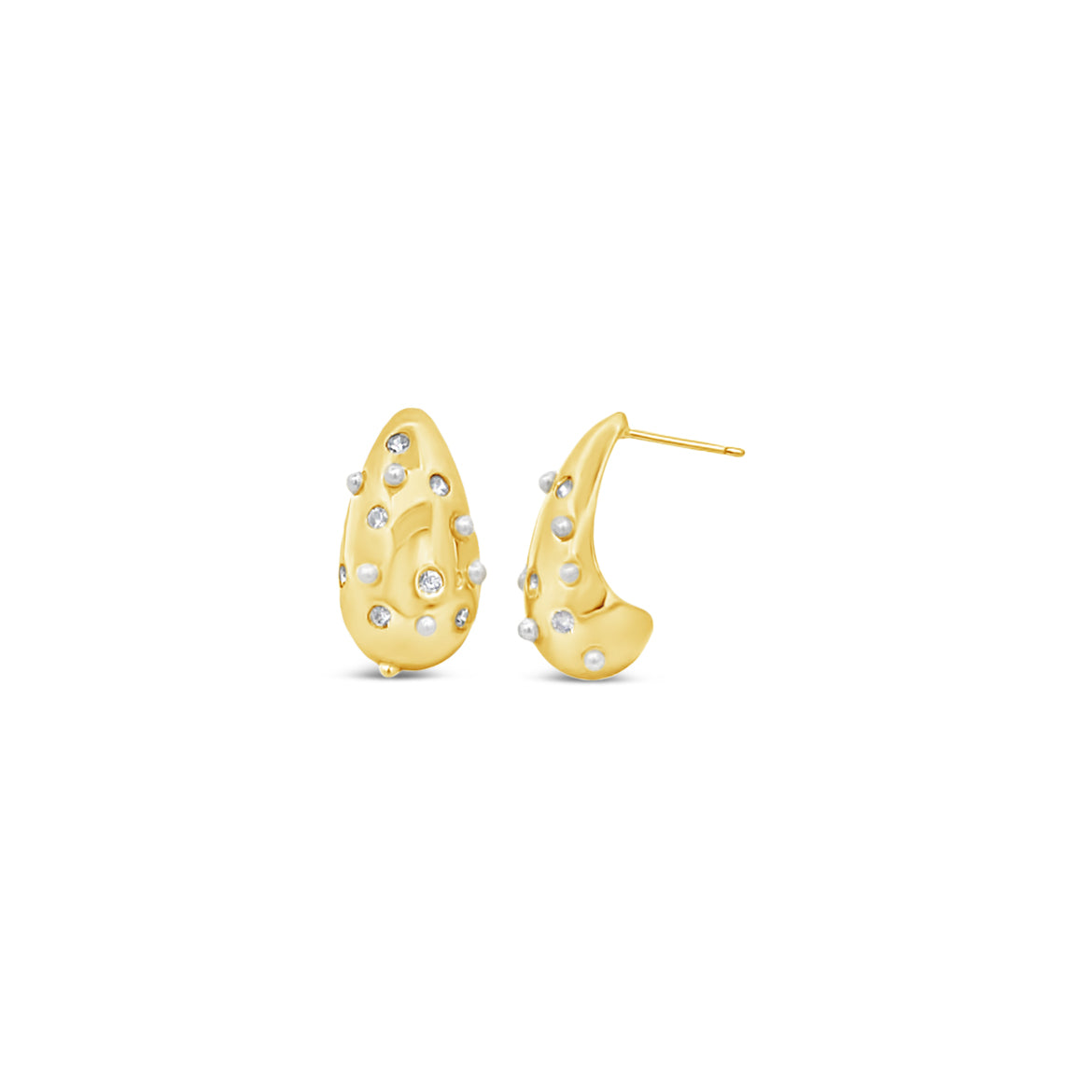 A pair of textured gold huggie earrings sparkles with scattered diamonds and pearls against a white background.