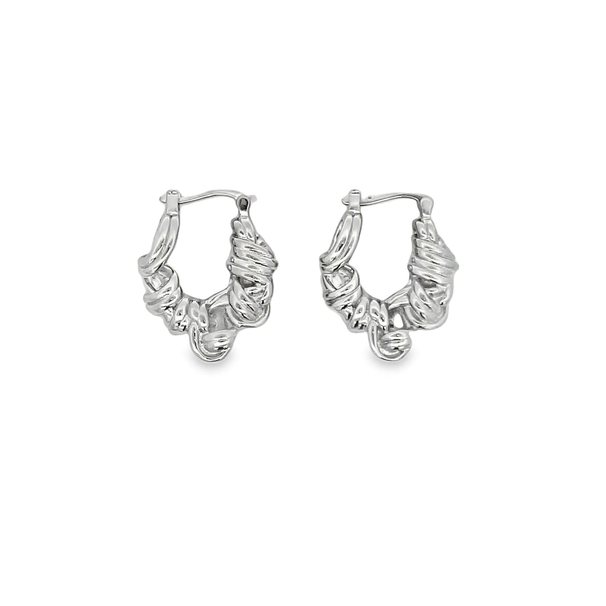 A pair of silver hoop earrings features an intricate, textured, twisted design against a plain white background.