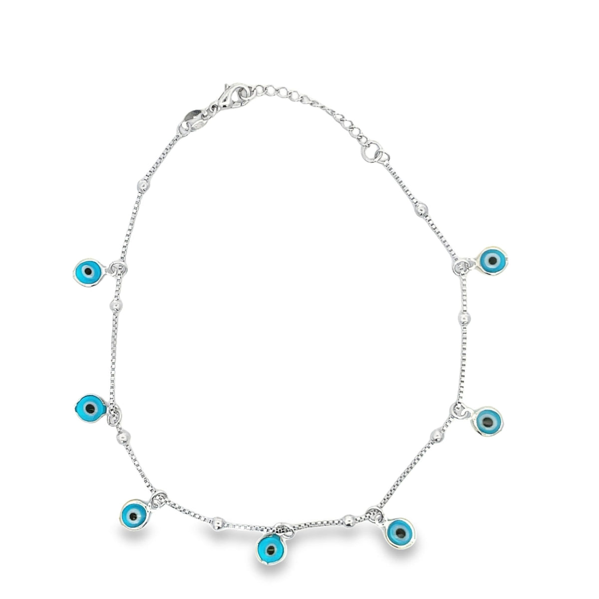 A delicate sterling silver anklet features dangling blue and white evil eye charms along its chain.