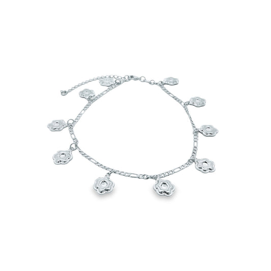 A delicate silver flower charm anklet rests in a circle on a white background.