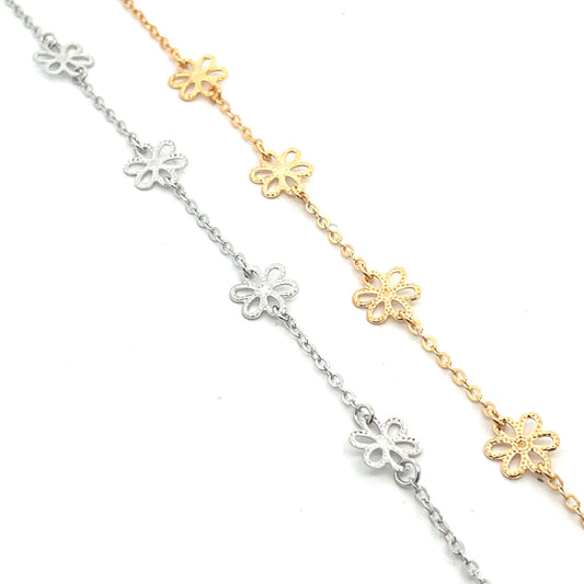 Two delicate chains feature silver and gold floral charms arranged diagonally against a clean white background.
