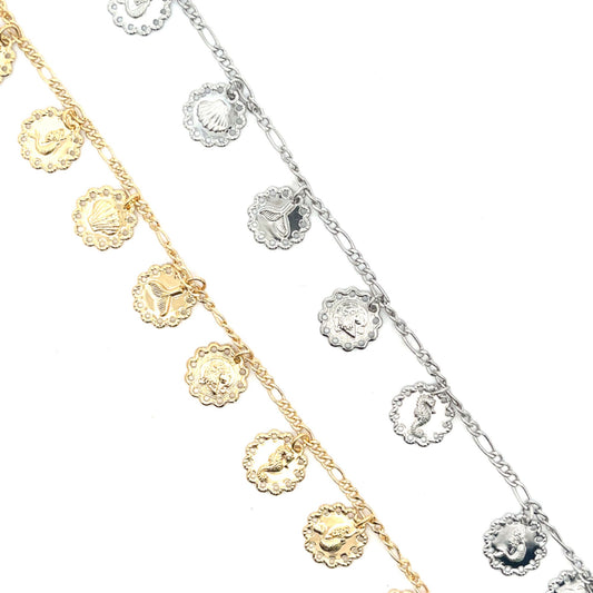 Two gold and silver charm bracelets showcase intricate ocean-themed pendants featuring seashells, mermaid tails, and seahorses against a clean white background.