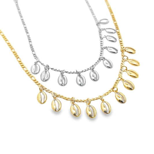 Two layered necklaces feature hanging cowrie shell charms, with one chain in polished silver and the other in gleaming gold.