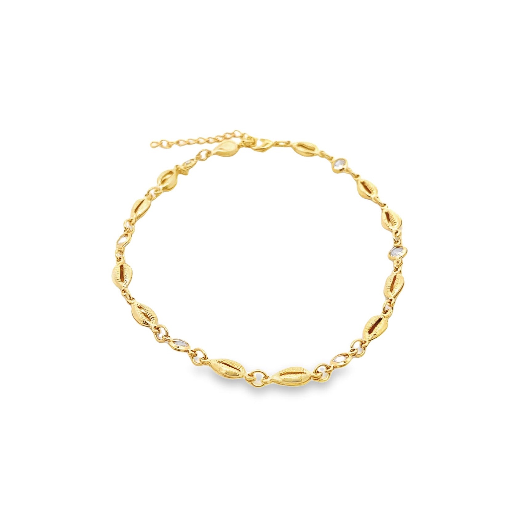 A gold shell anklet features alternating cowrie shell charms and sparkling crystal accents on a delicate chain.