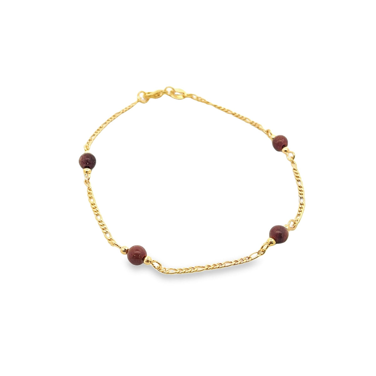 A delicate gold link bracelet features small, deep red gemstone beads evenly spaced along the chain against a white background.