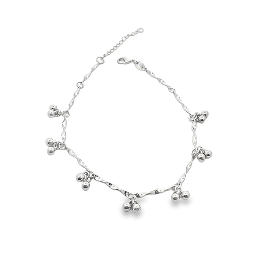A shimmering silver anklet displays delicate twisted links adorned with dangling small ball charms against a clean white background.