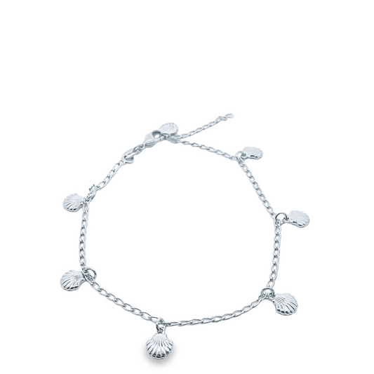 A delicate silver anklet features several hanging seashell charms arranged along its chain.