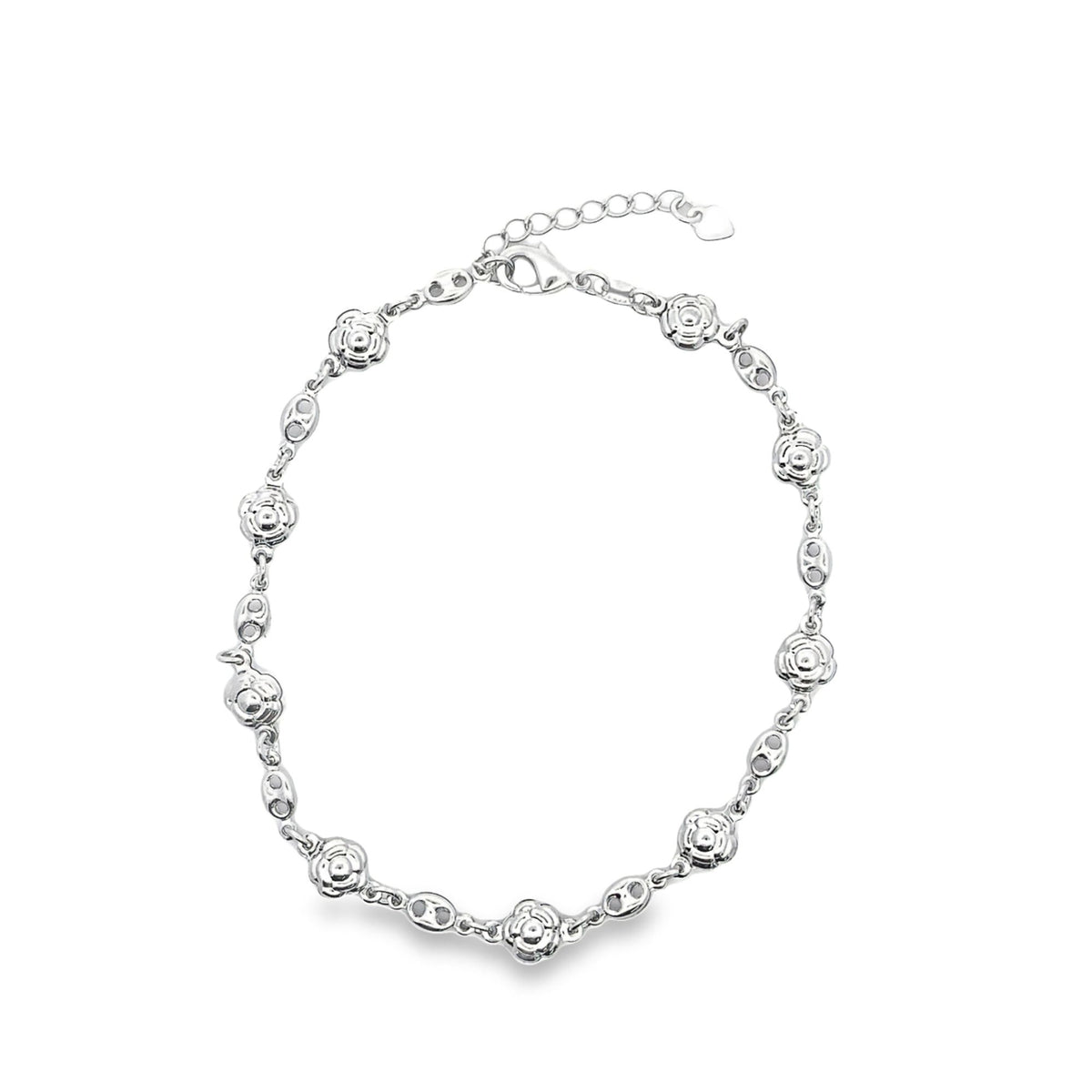 A delicate silver anklet featuring alternating flower charms and links rests against a clean white background.