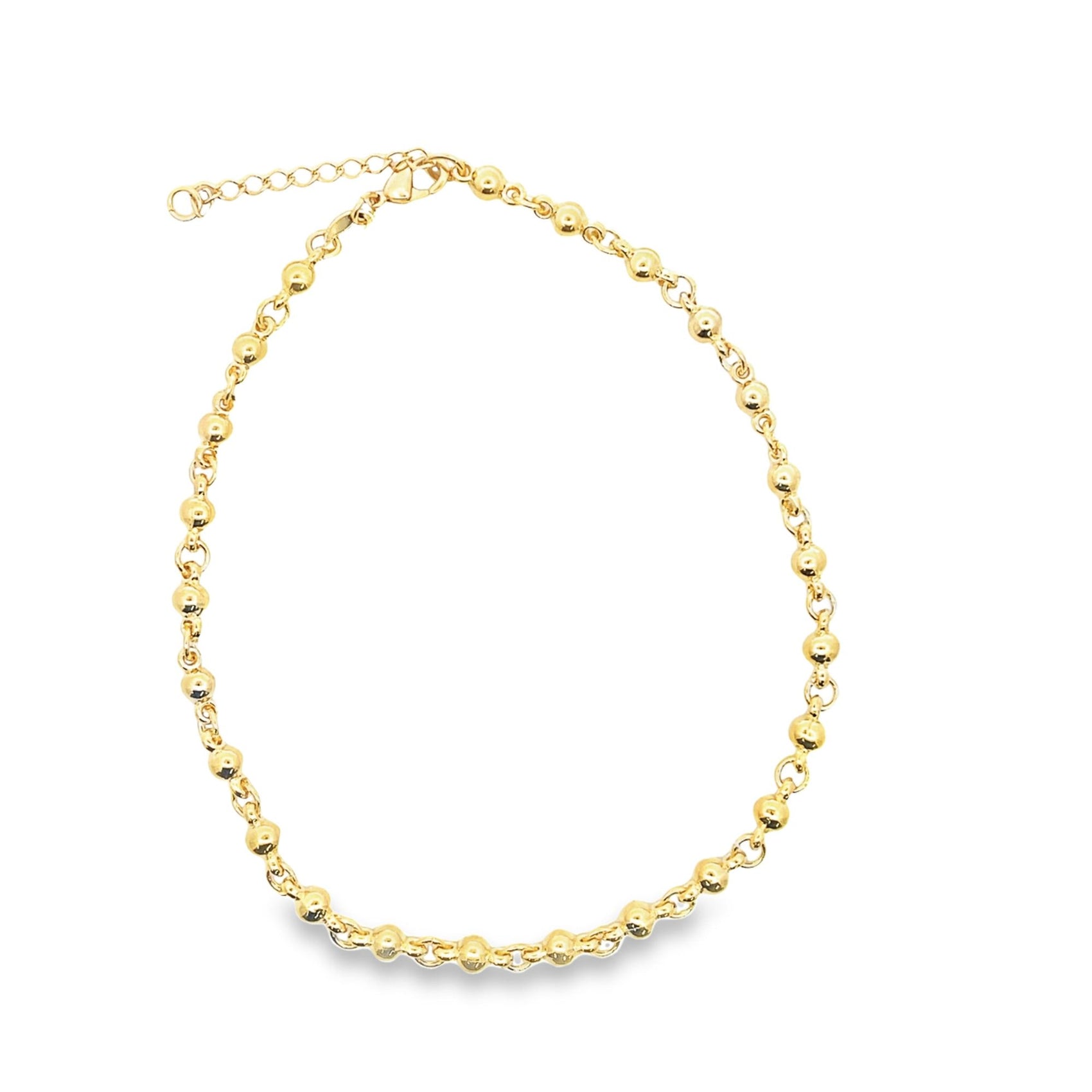 A shiny gold bead chain necklace rests in a circle on a white background.