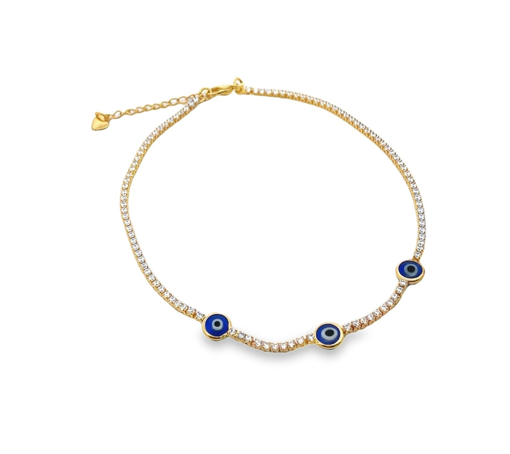 A gold tennis anklet encrusted with sparkling rhinestones features three blue evil eye charms displayed against a plain white background.
