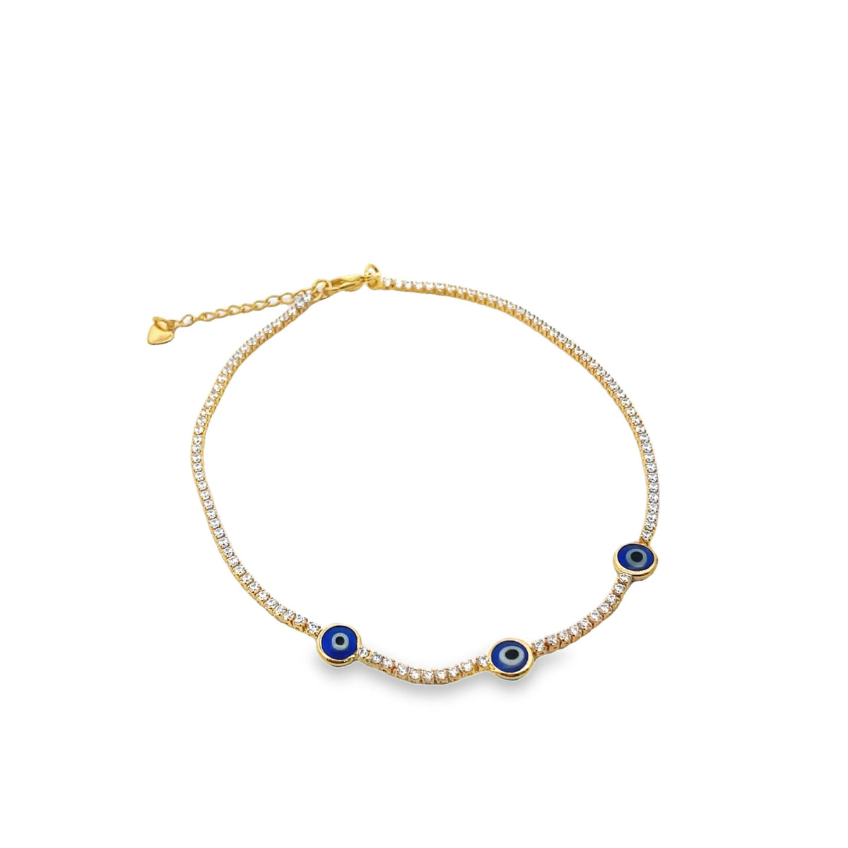A gold tennis anklet adorned with sparkling cubic zirconia stones features three vibrant blue evil eye charms against a clean white background.