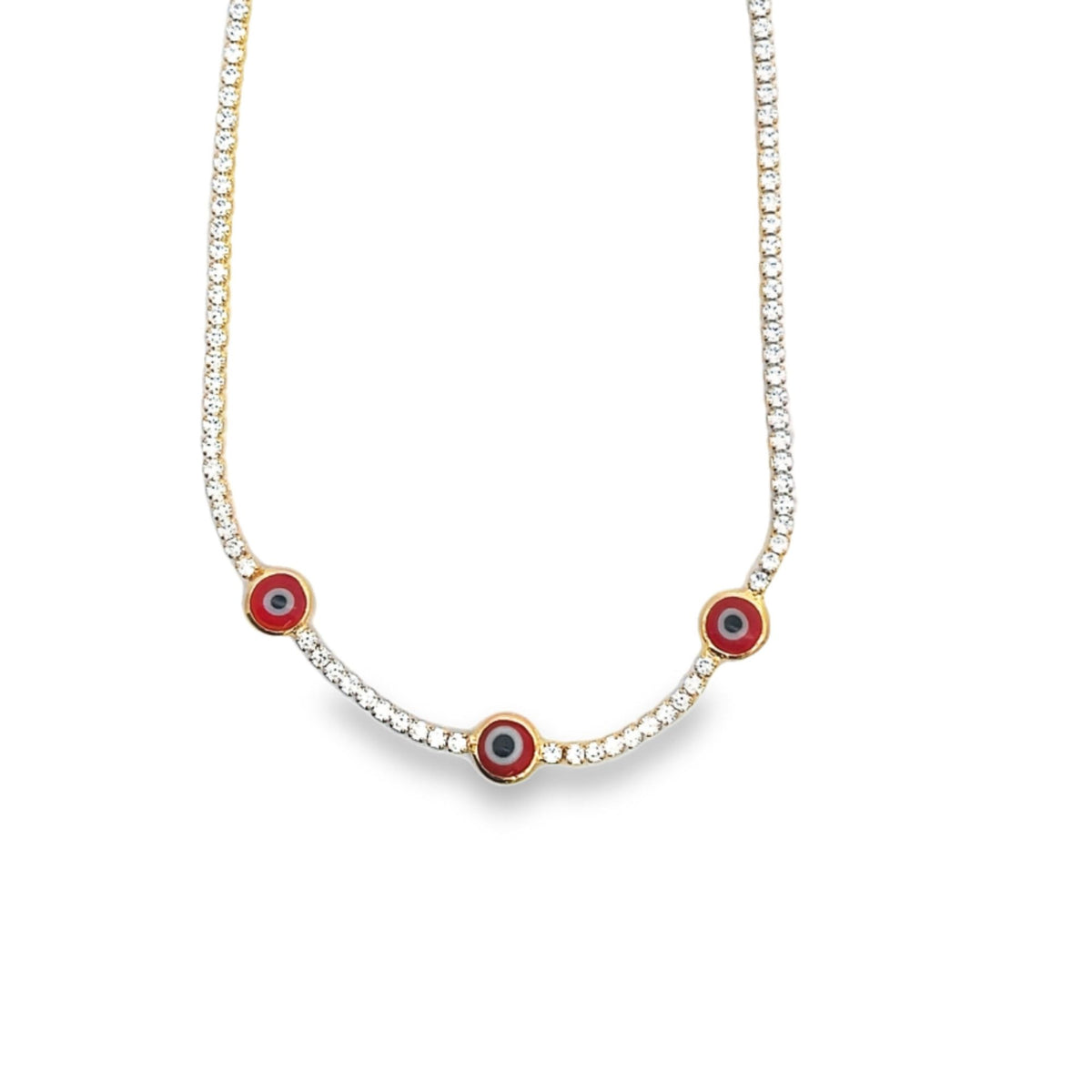 A dazzling diamond tennis necklace features three striking red evil eye charms against a white background.
