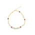 A gold chain necklace features alternating elephant charms and reddish-brown gemstone beads.