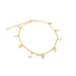 A delicate gold charm anklet displays dangling charms including crescent moons, flowers, and teardrops against a plain white background.
