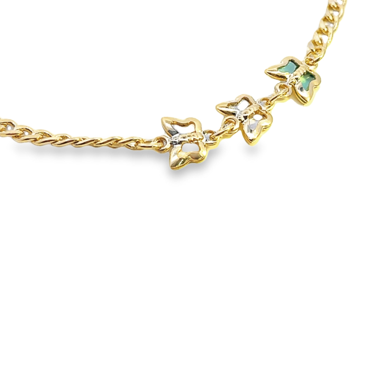 A delicate gold chain bracelet features three linked butterfly charms with white and green gemstone accents against a plain white background.