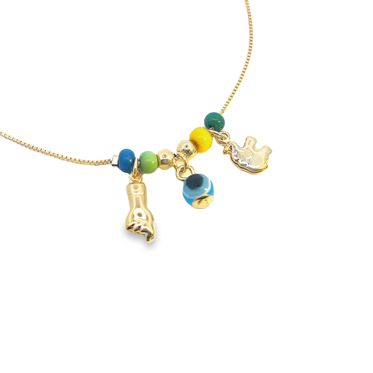 A delicate gold chain necklace showcases colorful beads, an evil eye amulet, a figa charm, and a hamsa hand pendant against a white background.