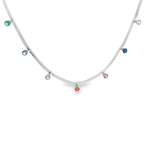 A delicate silver herringbone chain necklace features dangling multi-colored gemstone charms spaced evenly along its length.