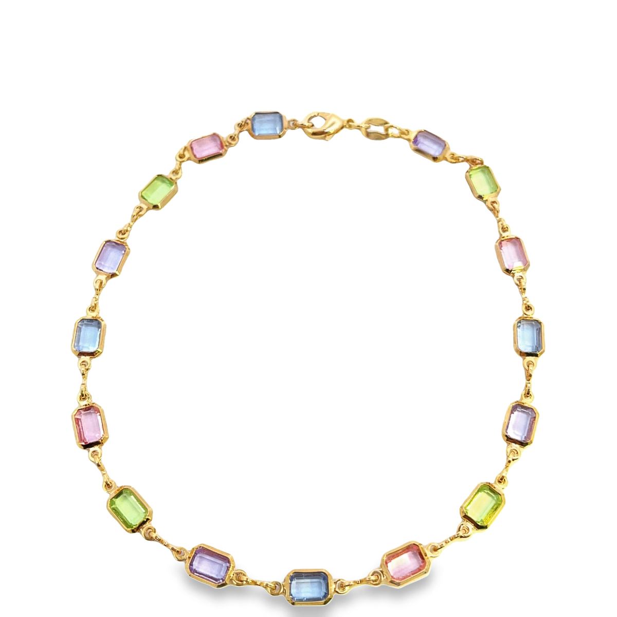 A gold chain necklace displays a repeating pattern of rectangular pastel gemstone crystals in shades of blue, green, pink, and purple.