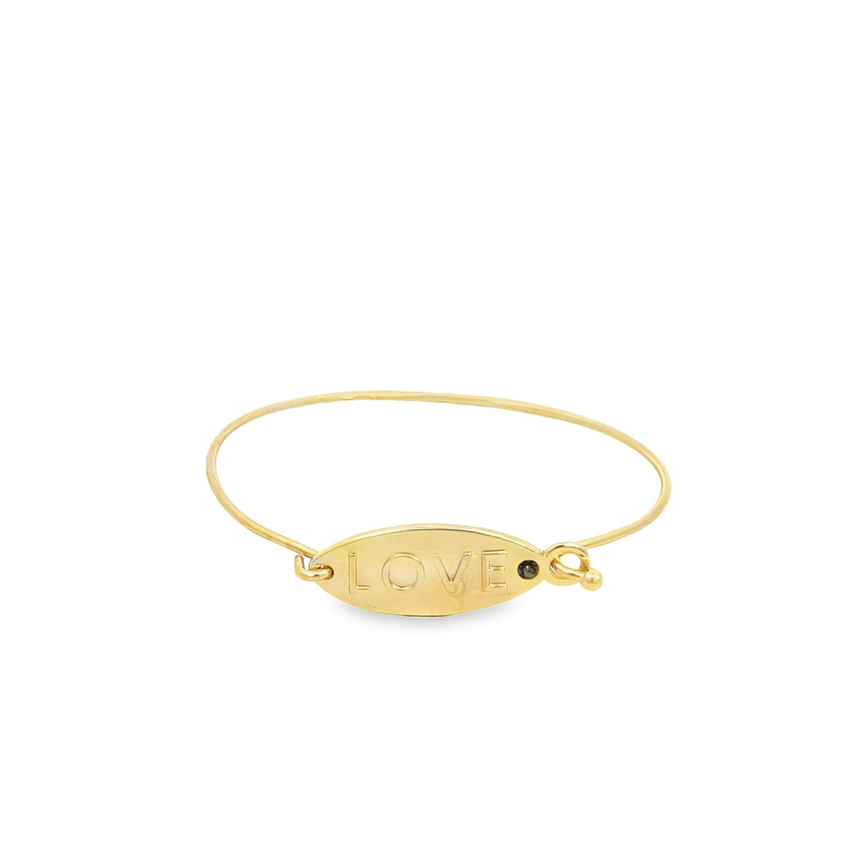 A delicate gold bangle bracelet features an oval plaque engraved with the word "LOVE" and a small black gemstone.