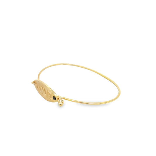 A delicate gold bangle bracelet features an engraved oval plate with the word "LOVE" and a small black gem accent against a clean white background.