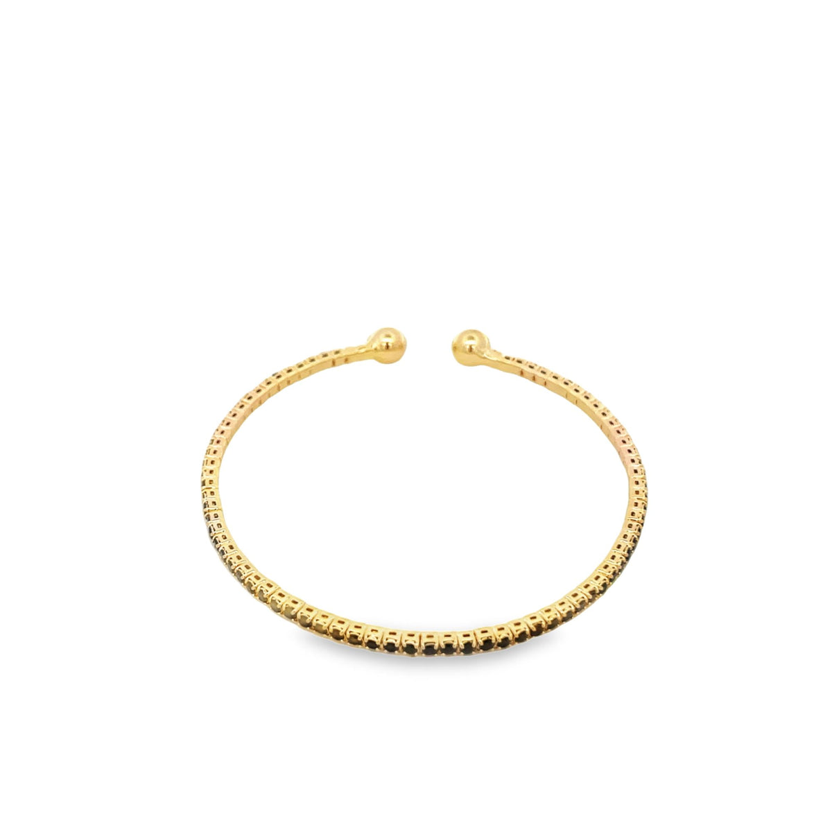 A delicate gold open ring features a continuous row of sparkling black stones and two small ball ends against a clean white background.
