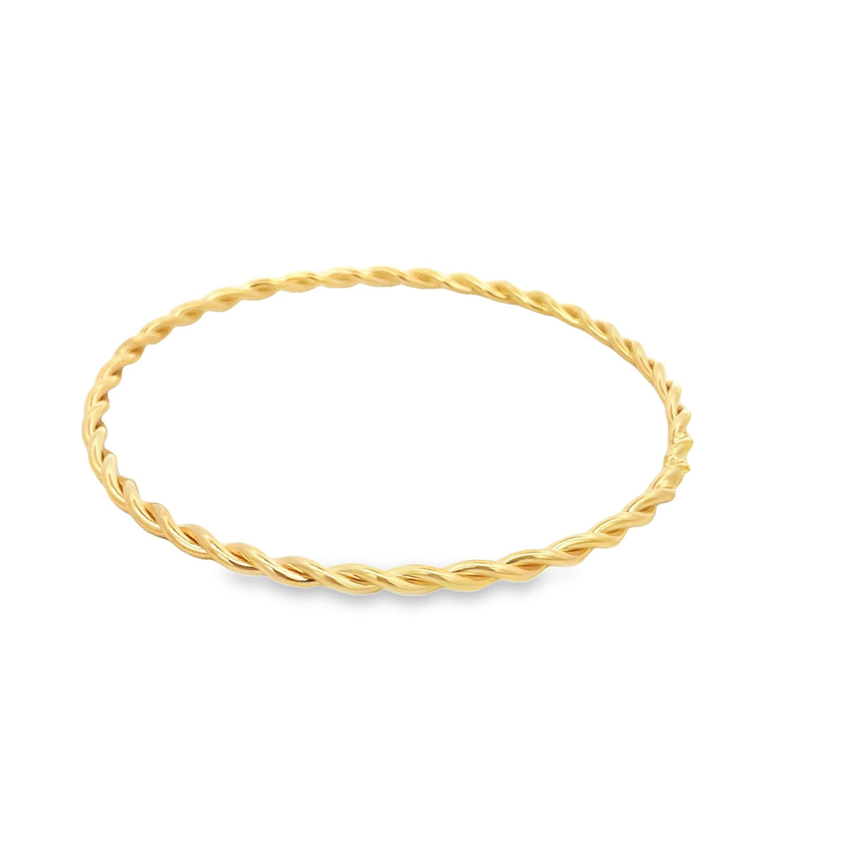 A slim gold twisted wire bangle rests against a plain white background.