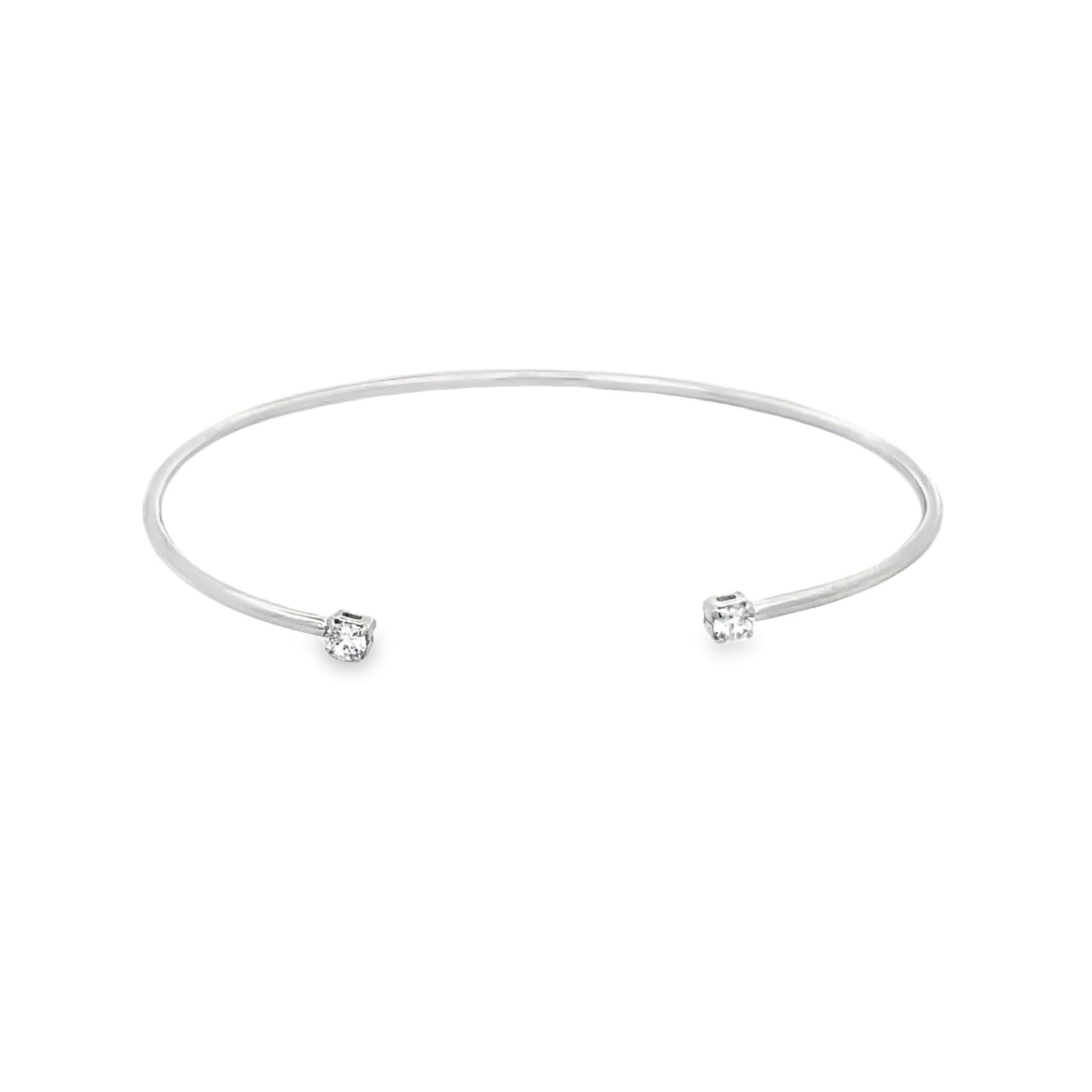 A sleek silver cuff bracelet features a sparkling diamond set at each open end against a clean white background.