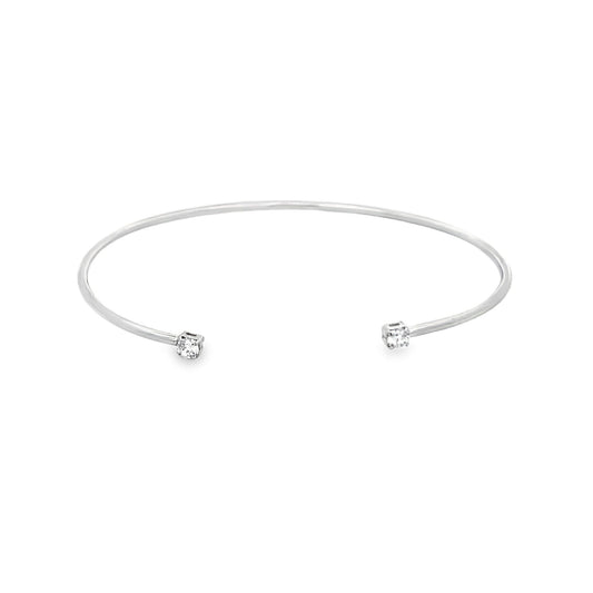 A sleek silver cuff bracelet features a sparkling diamond set at each open end against a clean white background.