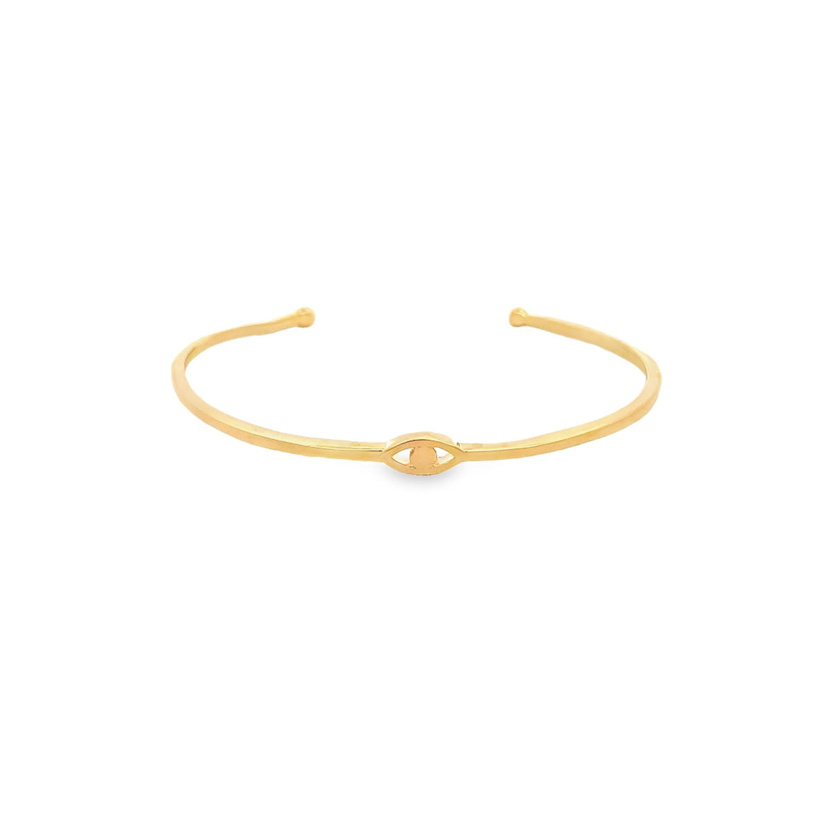 A minimalist gold cuff bracelet features a delicate evil eye motif centered on the band against a clean white background.