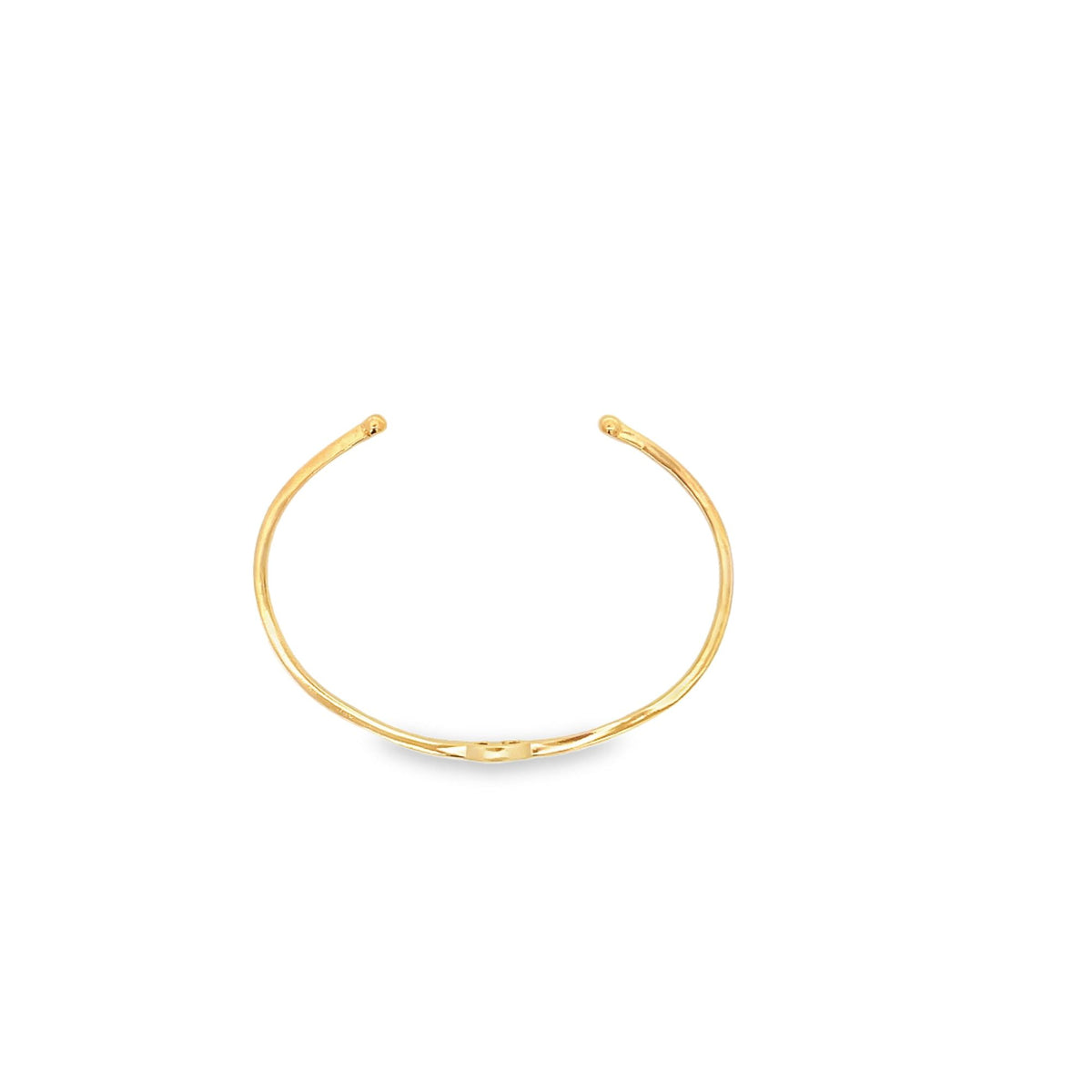 A minimalist gold cuff bracelet rests on a clean white background.