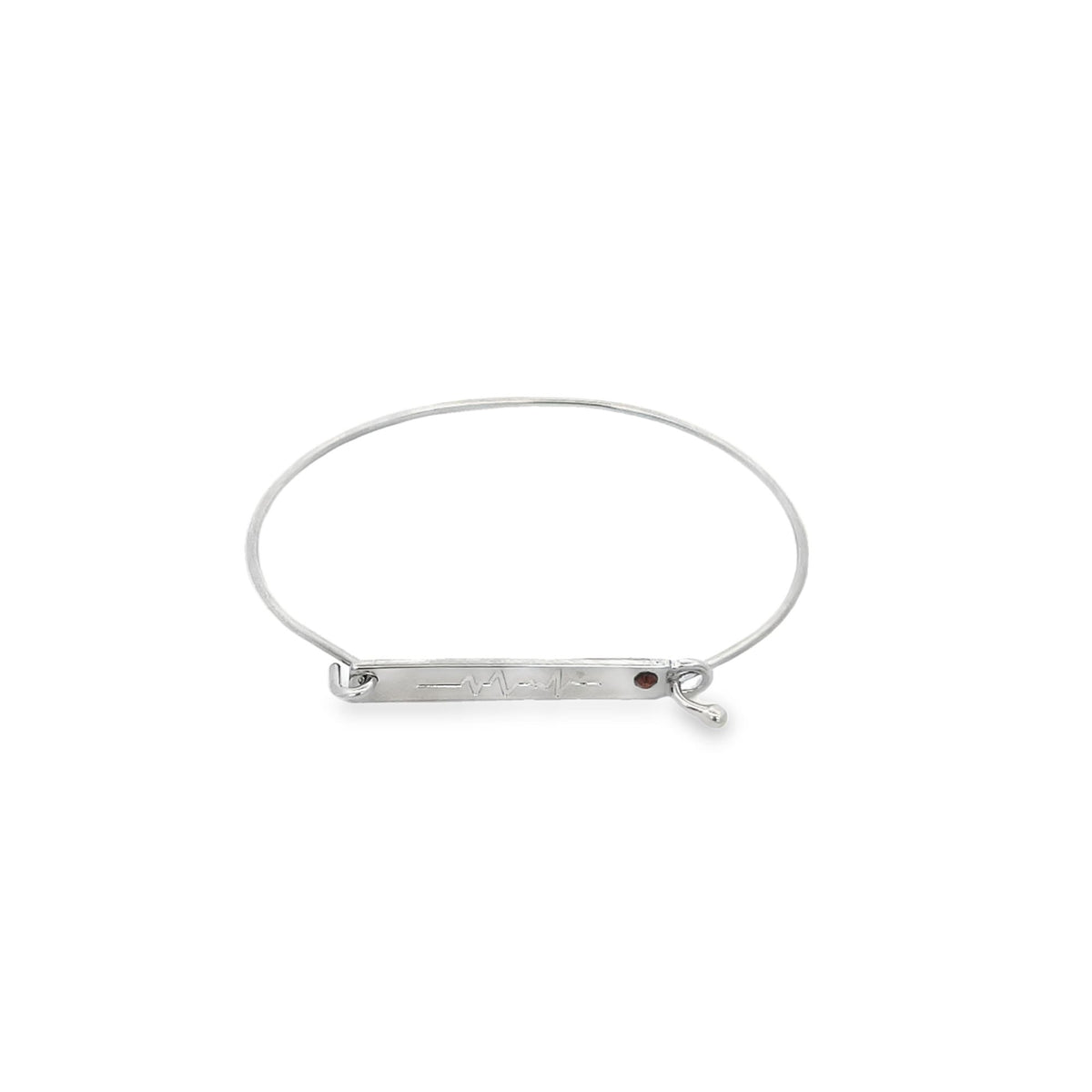 A silver wire bangle bracelet features an engraved heartbeat ECG line and a small red gemstone on a central bar against a white background.