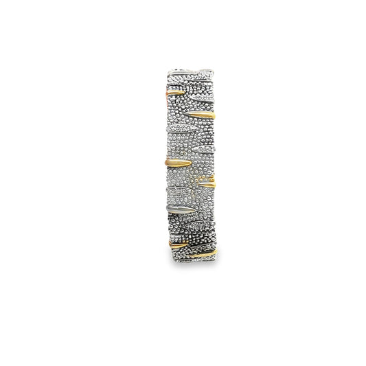 A textured sterling silver band ring features oxidized detailing interspersed with polished gold and diamond accents against a plain white background.