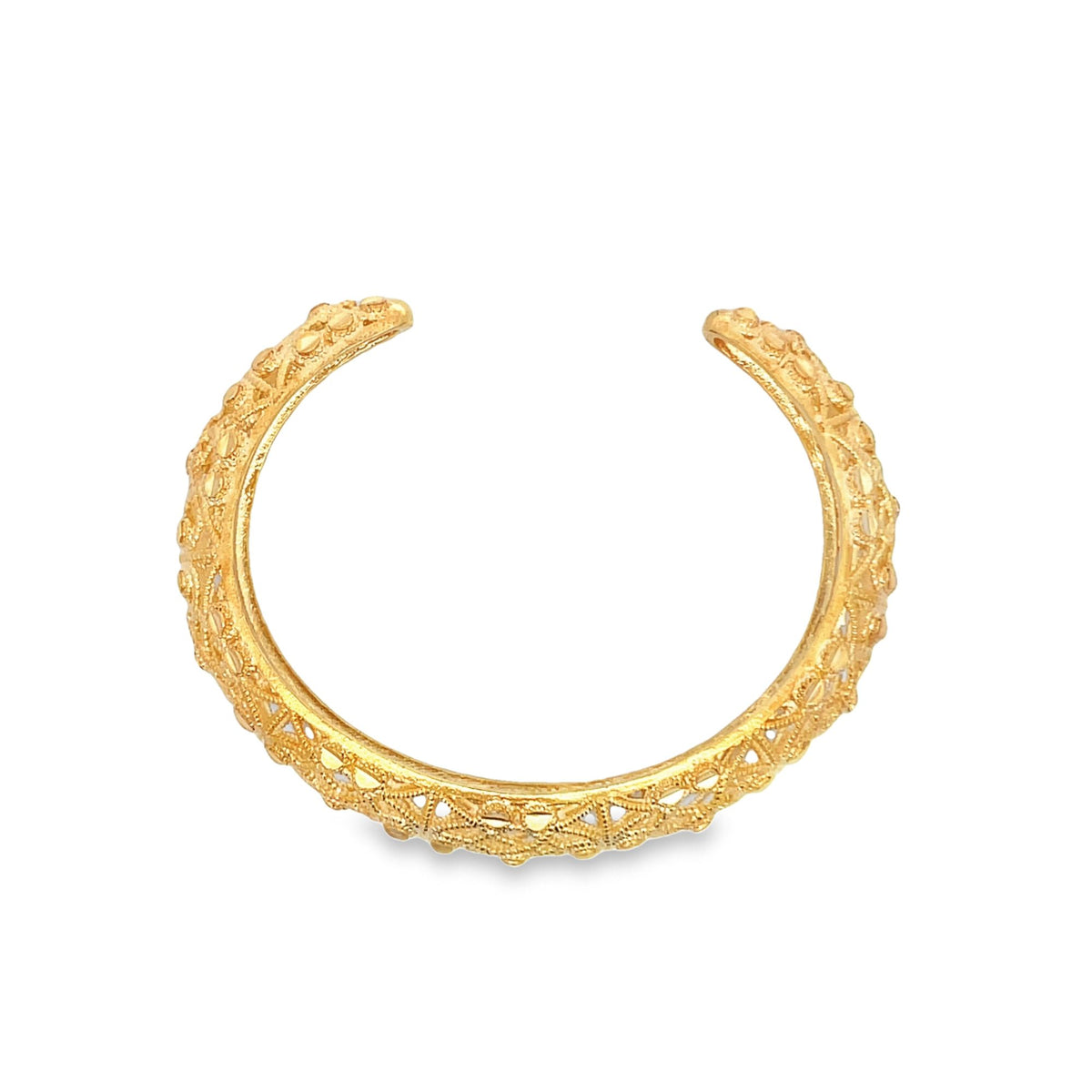 An intricate, open-ended gold bangle bracelet features delicate filigree work and beaded detailing against a clean white background.