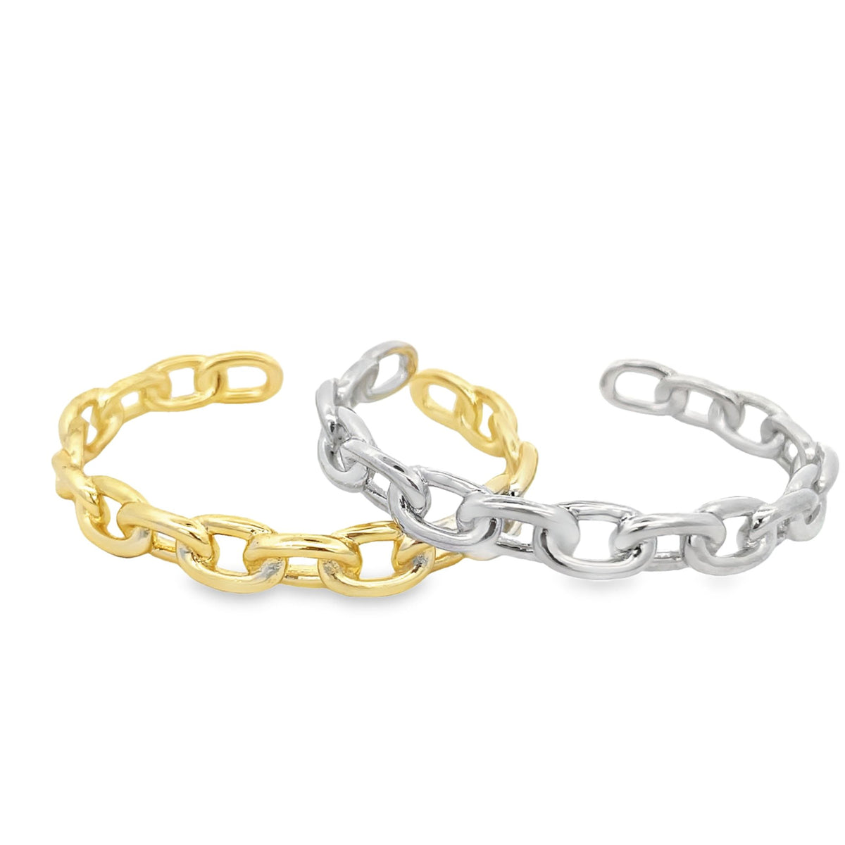 Two interlocking chain-link cuff rings in gold and silver rest against a white background.