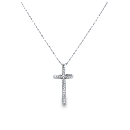 A delicate silver cross pendant embellished with sparkling diamonds hangs from a matching box chain against a white background.
