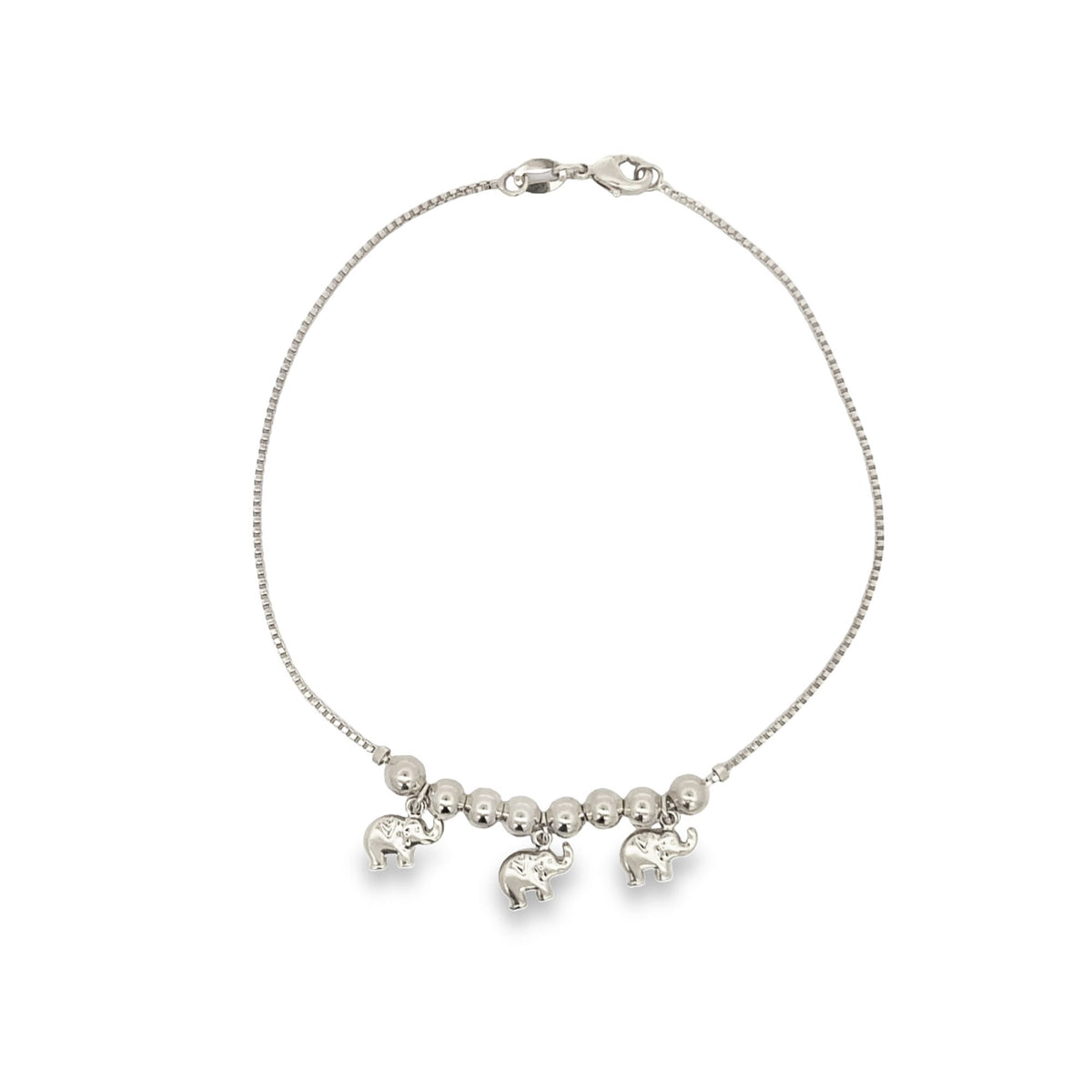 A delicate silver box chain bracelet features three dangling elephant charms interspersed with polished beads against a plain white background.