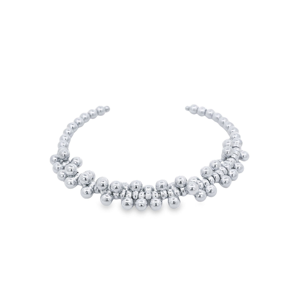 A polished sterling silver beaded cuff bracelet rests on a white background.