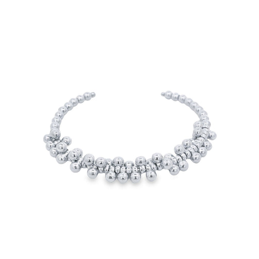 A polished sterling silver beaded cuff bracelet rests on a white background.