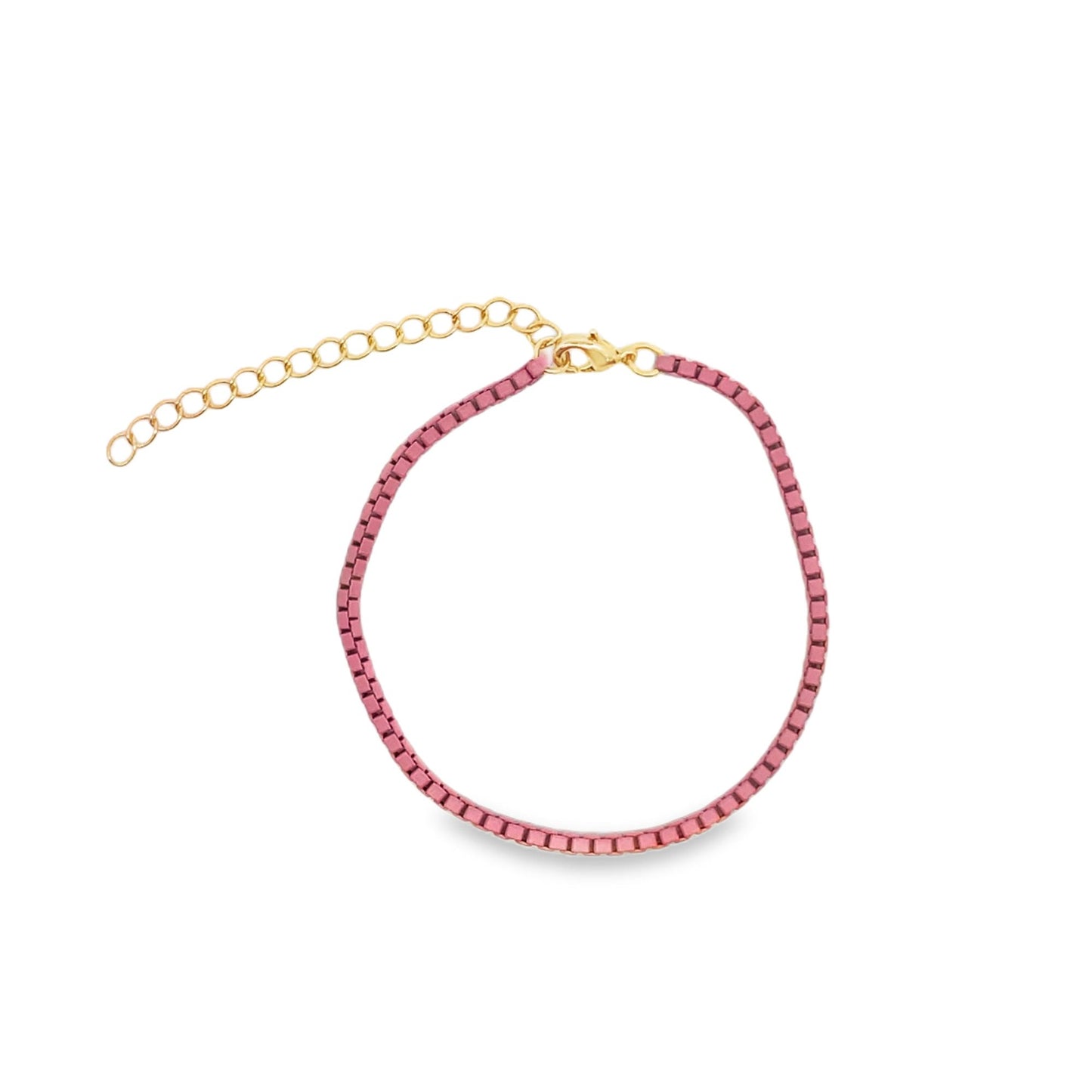 A pink velvet bracelet with an adjustable gold chain sits against a white background.