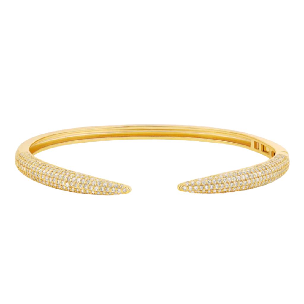 A gold pavé diamond cuff bracelet rests against a clean white background.