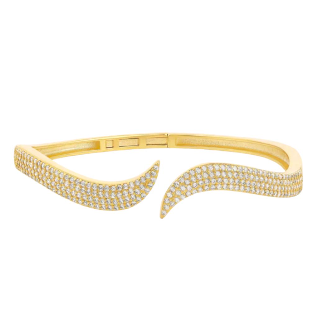 A gold pave diamond bangle bracelet curves in a wavy, open-ended design against a plain white background.