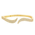A gold cuff bracelet sparkles with pavé-set diamonds on its undulating ends.