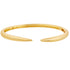 A sleek gold cuff bracelet rests horizontally against a plain white background, showcasing its tapered, pointed ends and polished finish.
