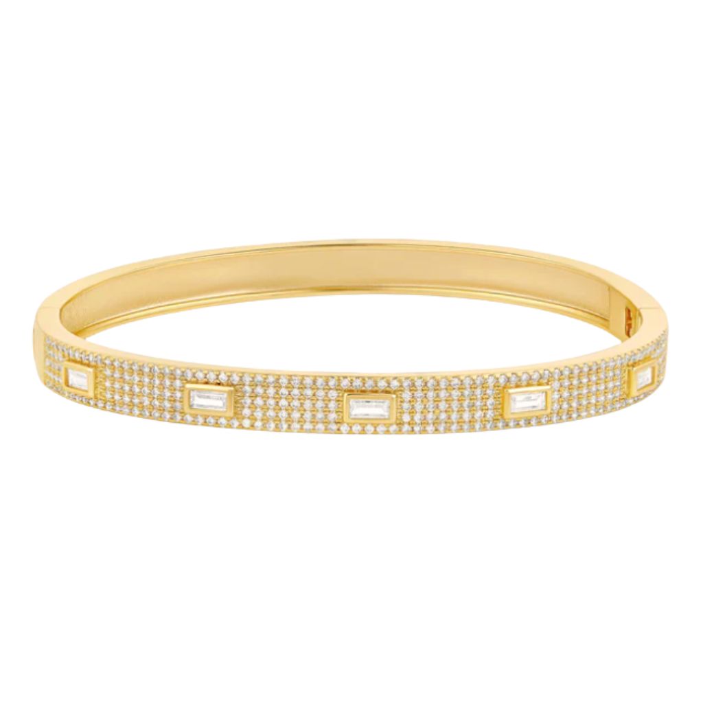A gold bangle bracelet sparkles with pavé diamonds and features five evenly spaced baguette-cut stones.