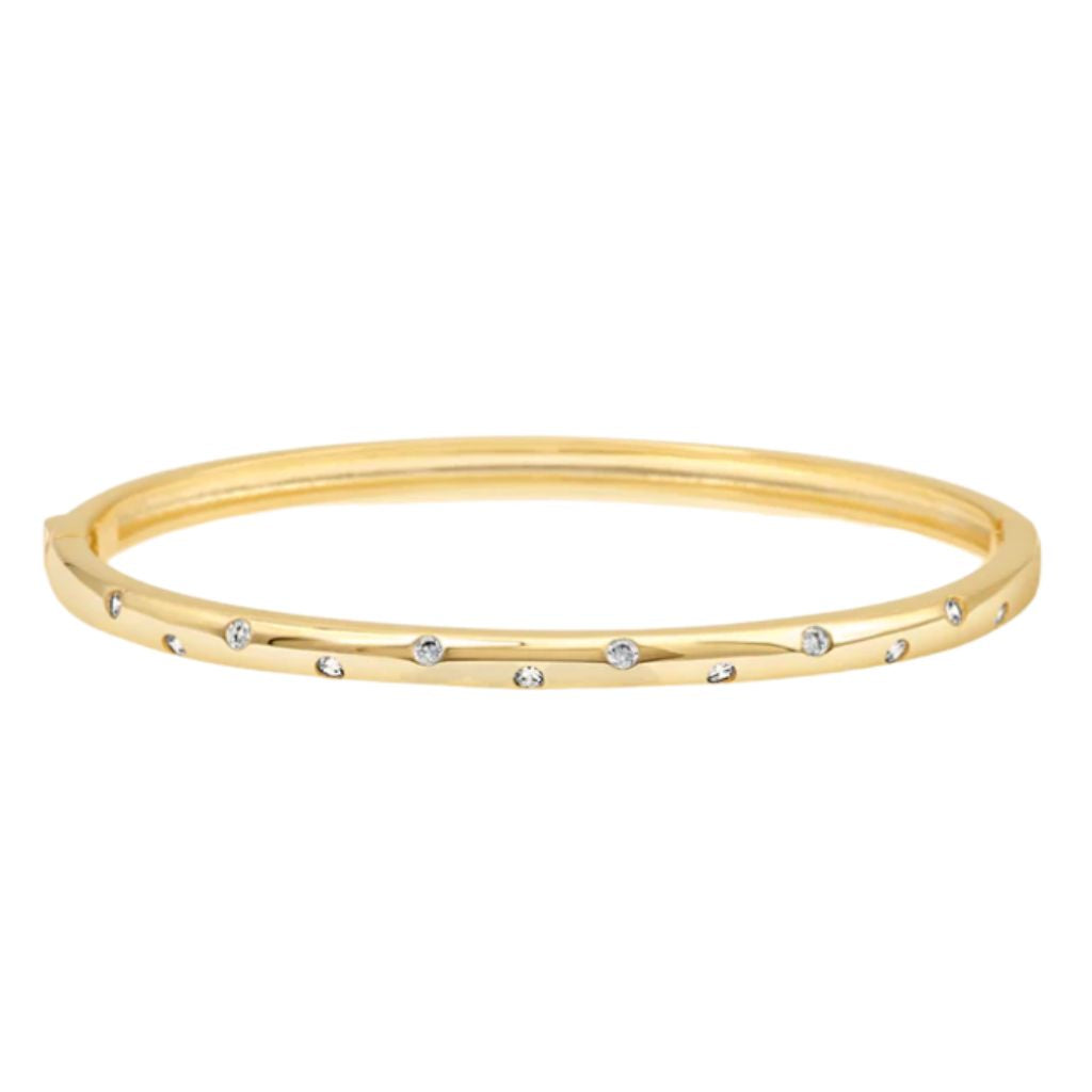 A gold bangle bracelet sparkles with evenly spaced diamonds flush-set along its polished surface.