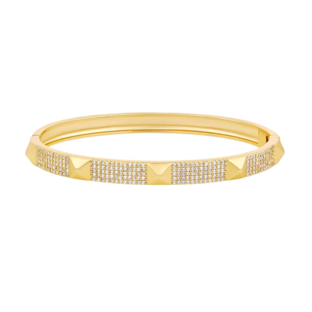A gold hinged bangle bracelet features alternating sections of pavé-set crystals and smooth pyramidal studs against a clean white background.