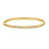 A gold hinged bangle bracelet features three rows of sparkling pavé diamonds and smooth pyramid studs.