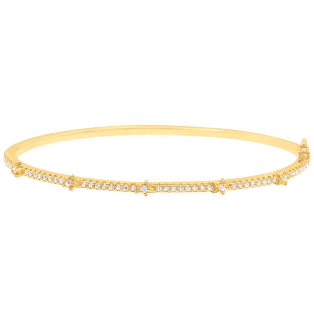 A gold diamond station bangle bracelet rests horizontally against a plain white background.