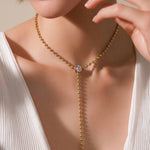 Elegant beaded lariat necklace with bezel-set stone and drop chain. Minimalist Y necklace available in gold or silver. Perfect for everyday wear or layering.